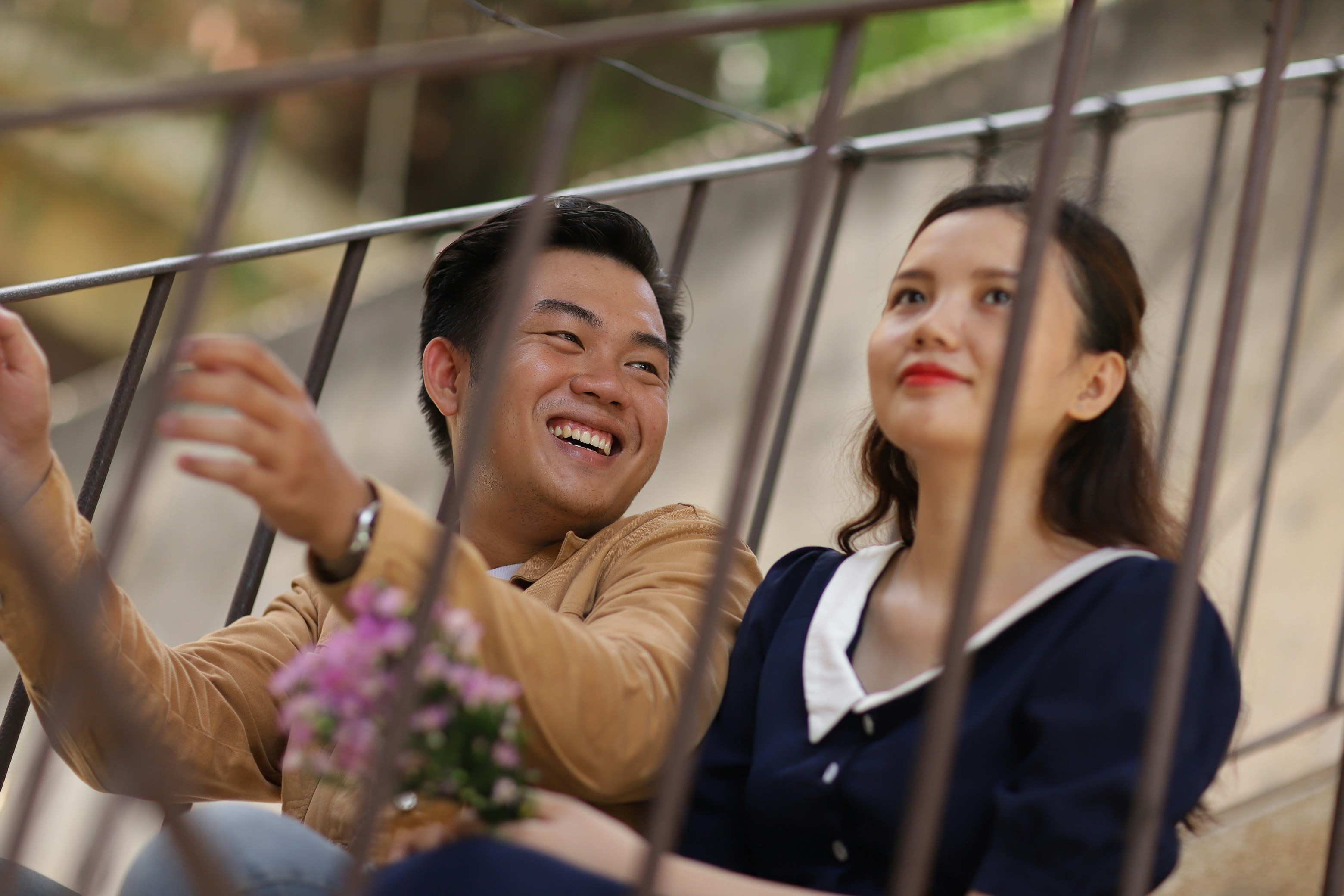 couple sitting behind grey metal railings